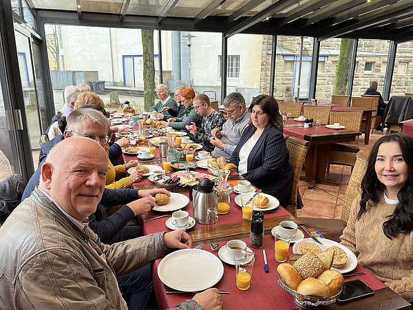 Mehrere Personen an einem langen Tisch